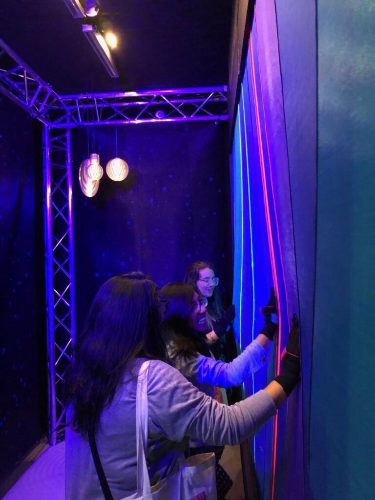 Visitors inside the installation touching the wall